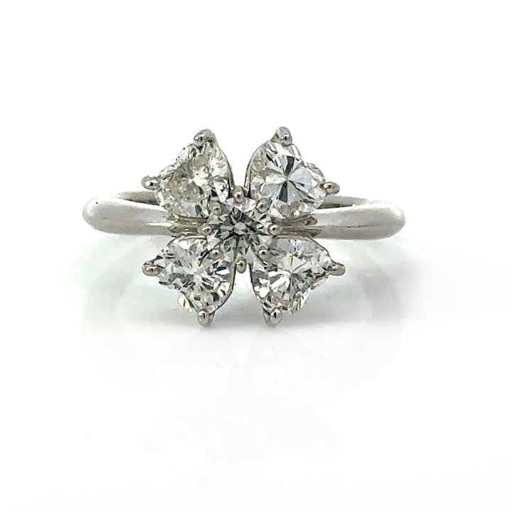 Front view of platinum diamond clover ring with four heart-shaped diamonds and round center