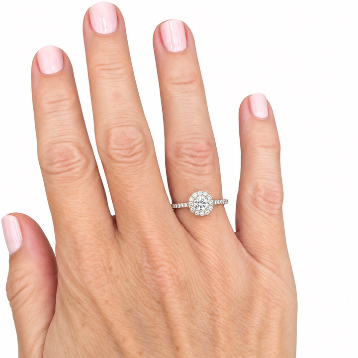 Estate round diamond halo ring in 14K yellow gold shown on hand