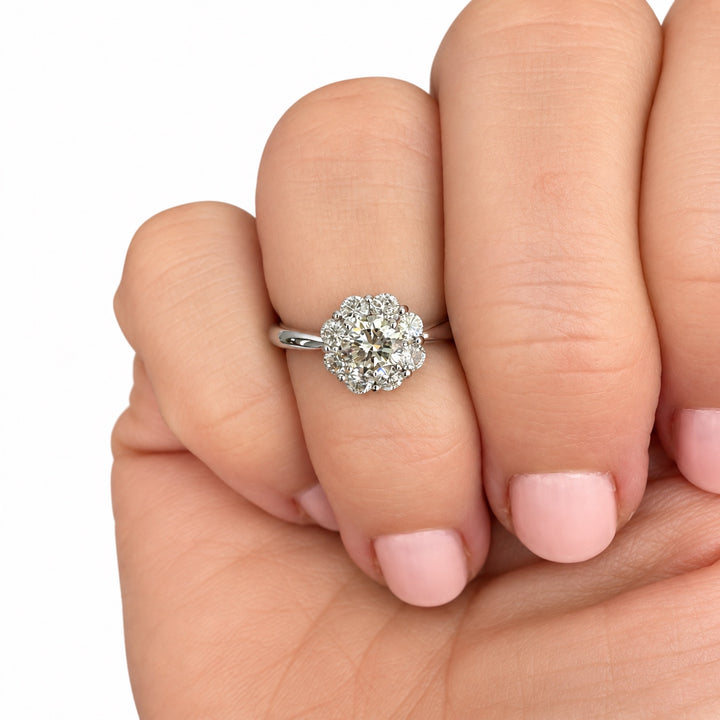 Vintage platinum diamond cluster ring shown on hand